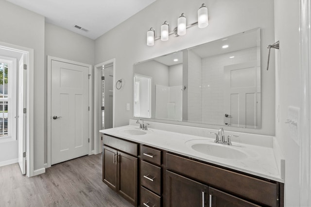 bathroom with walk in shower, vanity, and hardwood / wood-style flooring