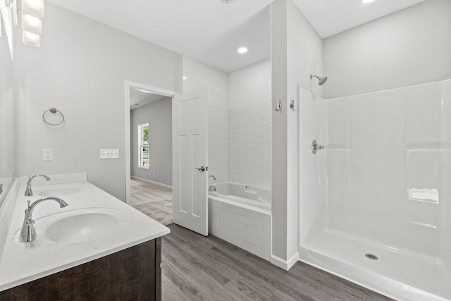 bathroom with wood-type flooring, vanity, and separate shower and tub