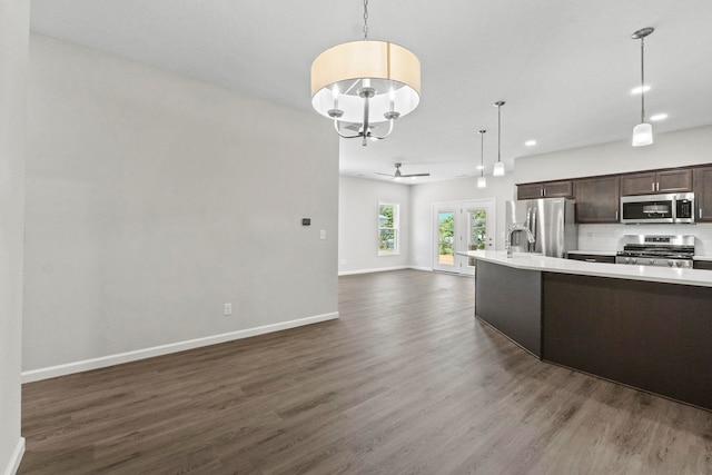 kitchen featuring dark brown cabinets, dark wood-type flooring, hanging light fixtures, stainless steel appliances, and ceiling fan