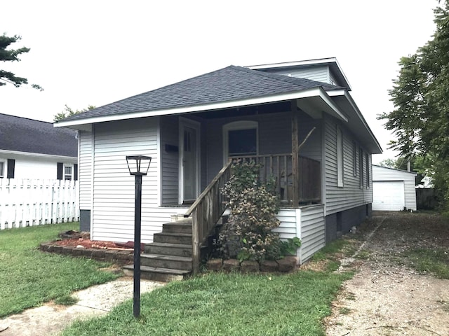 bungalow featuring a front yard, an outbuilding, and a garage