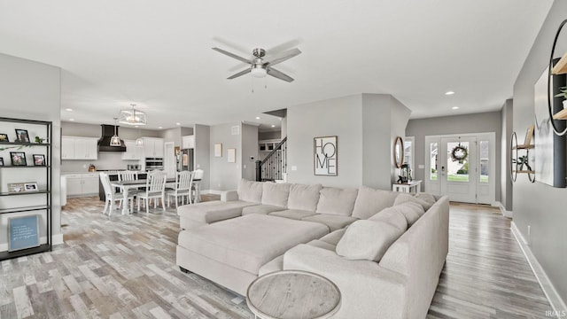 living room with light hardwood / wood-style flooring and ceiling fan