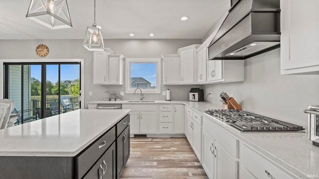 kitchen with a healthy amount of sunlight, premium range hood, and white cabinets