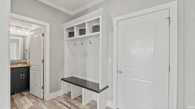 mudroom with ornamental molding and light hardwood / wood-style floors