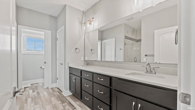 bathroom with walk in shower, vanity, and hardwood / wood-style flooring