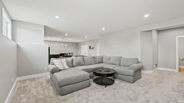 carpeted living room featuring a textured ceiling