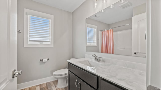 bathroom featuring walk in shower, vanity, toilet, and hardwood / wood-style flooring