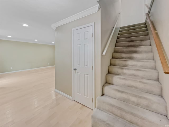 stairway with crown molding and hardwood / wood-style flooring