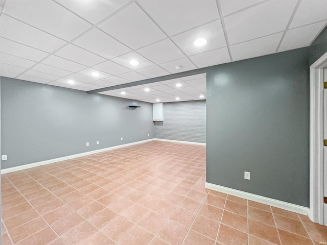 basement with light tile patterned floors and a paneled ceiling