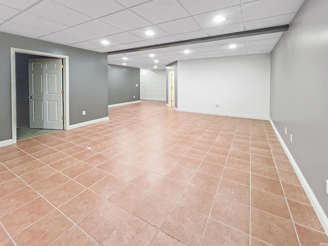 basement featuring light tile patterned floors and a drop ceiling