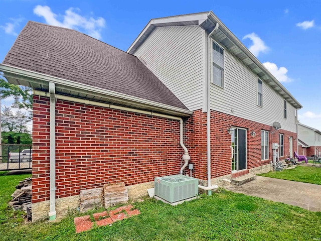 view of side of home with a lawn and central air condition unit