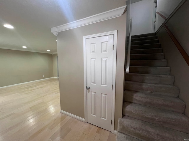 staircase featuring hardwood / wood-style floors and crown molding