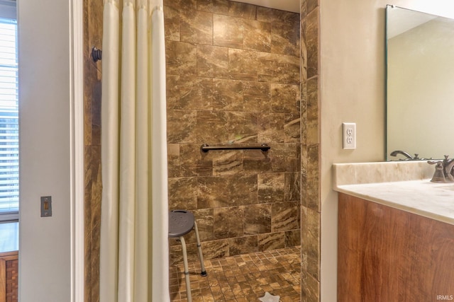 bathroom featuring a tile shower and vanity