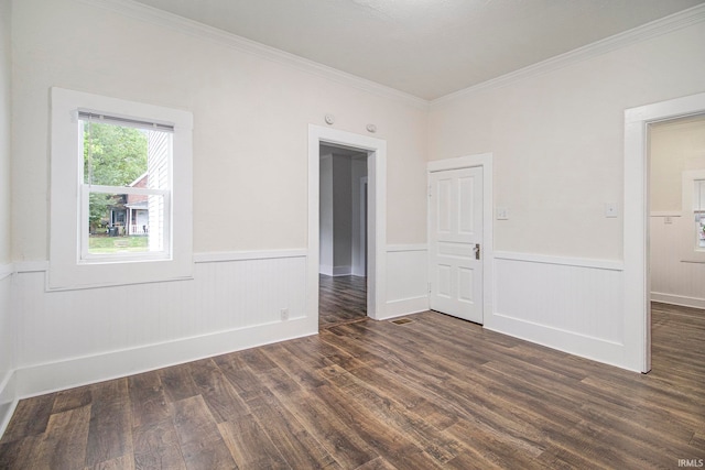 spare room with crown molding and dark wood-type flooring