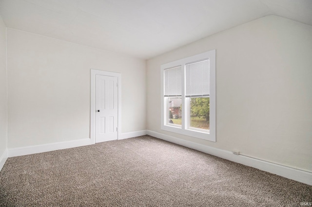 carpeted empty room with lofted ceiling