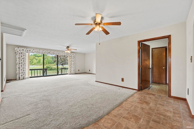 spare room featuring ceiling fan, a textured ceiling, and light carpet