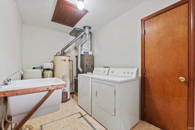 washroom featuring gas water heater, independent washer and dryer, and a textured ceiling