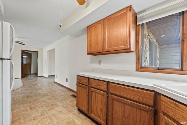 kitchen with ceiling fan, white fridge, and sink