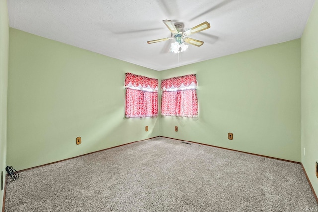 carpeted empty room with a textured ceiling and ceiling fan