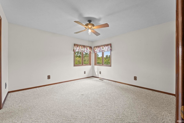 carpeted spare room featuring ceiling fan