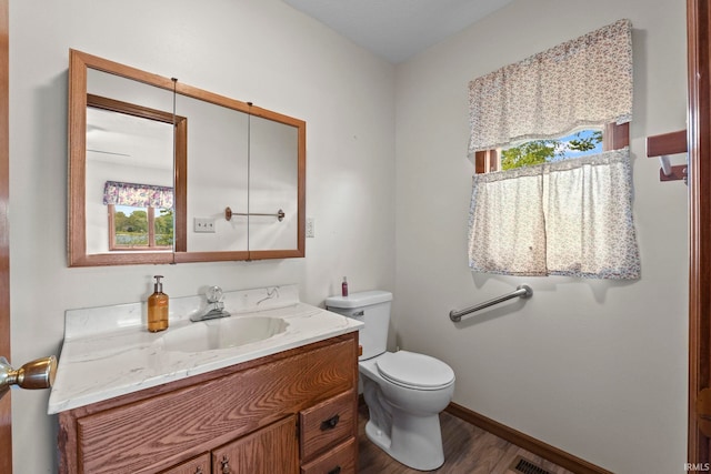 bathroom featuring hardwood / wood-style floors, plenty of natural light, vanity, and toilet