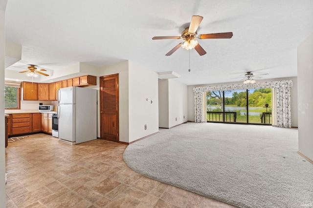 unfurnished living room with ceiling fan and a healthy amount of sunlight