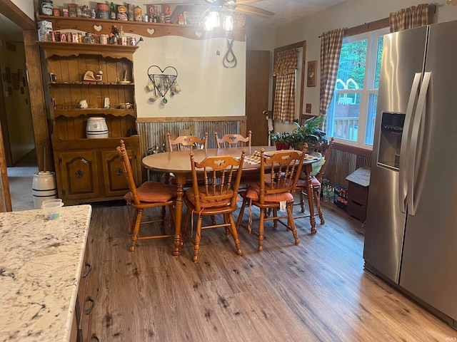 dining space with ceiling fan and hardwood / wood-style flooring