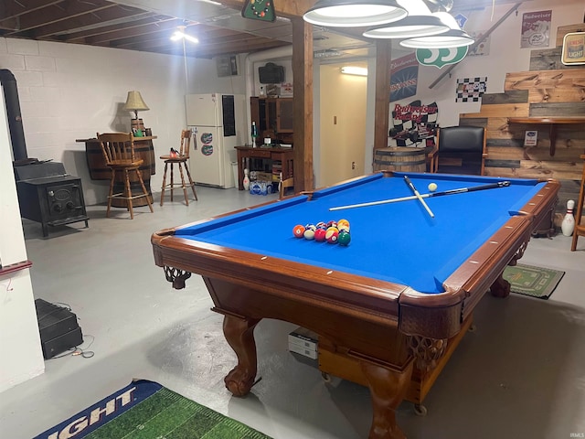 playroom featuring pool table, concrete floors, and a wood stove