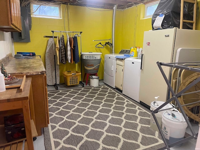 washroom with electric panel, independent washer and dryer, and cabinets