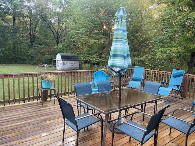 deck with a storage shed and a yard