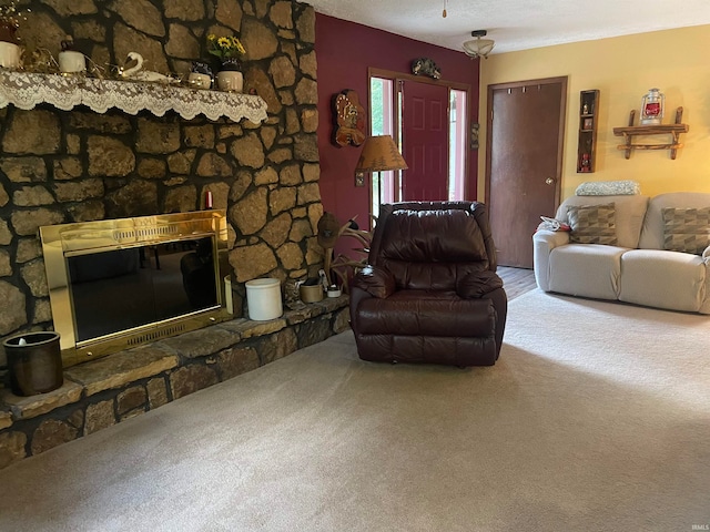 carpeted living room with a stone fireplace and a textured ceiling