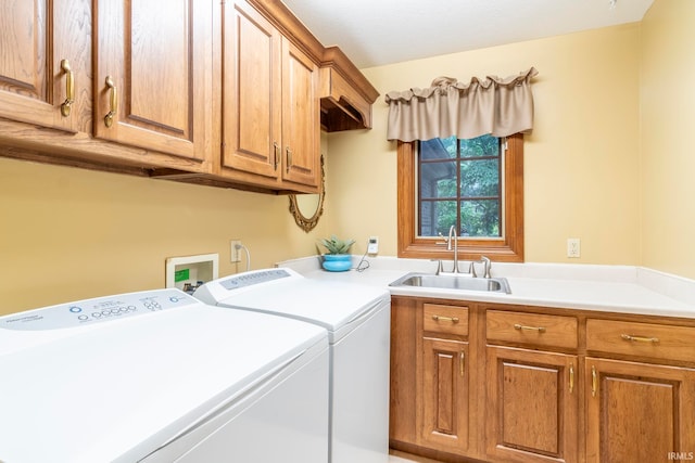 laundry room with cabinets, washing machine and dryer, and sink