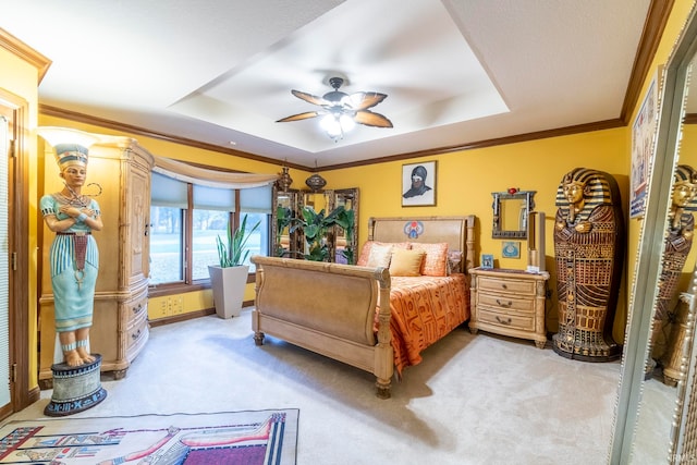 bedroom featuring carpet floors, crown molding, a tray ceiling, and ceiling fan