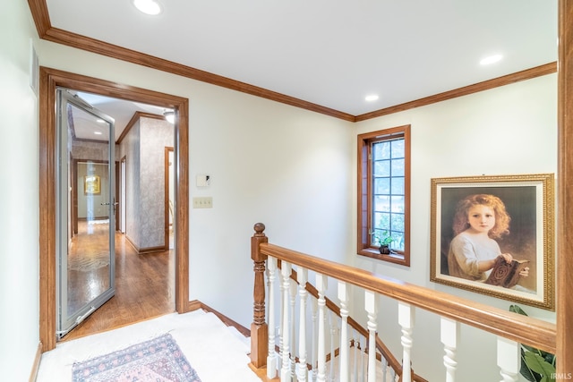 corridor with wood-type flooring and crown molding