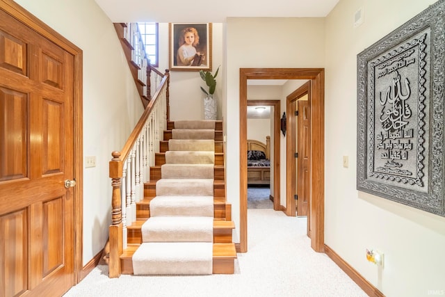 stairs featuring carpet flooring