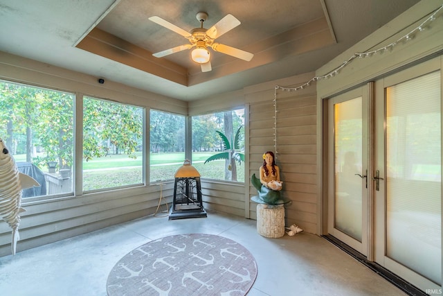 sunroom / solarium featuring a raised ceiling, ceiling fan, and a wealth of natural light