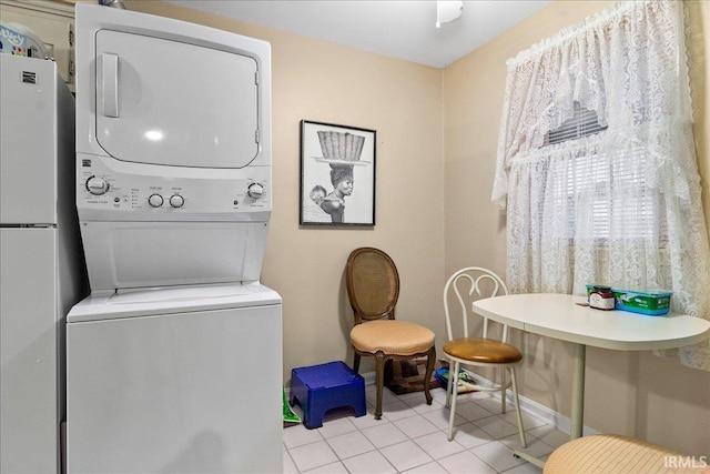 laundry room featuring stacked washer / drying machine and light tile patterned floors