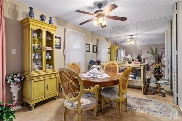 dining area featuring ceiling fan and light carpet