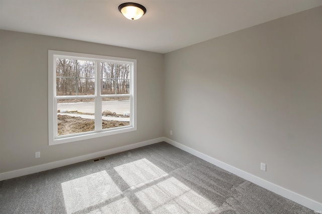 carpeted empty room with visible vents and baseboards