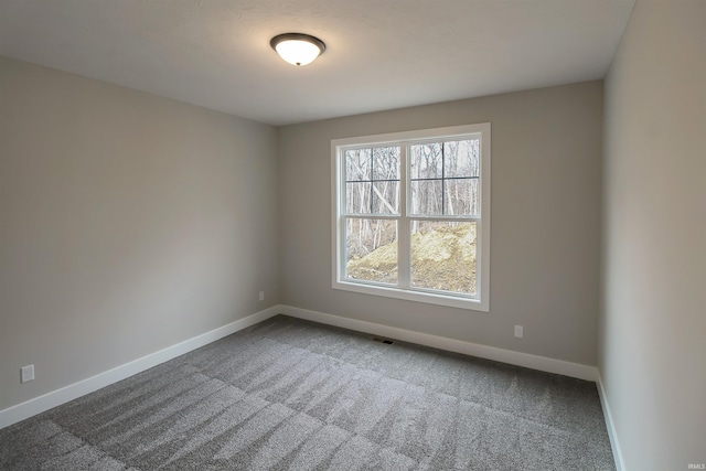 carpeted empty room with visible vents and baseboards