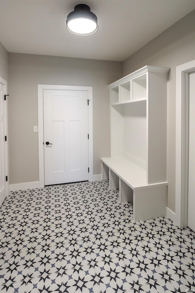 mudroom featuring light floors and baseboards