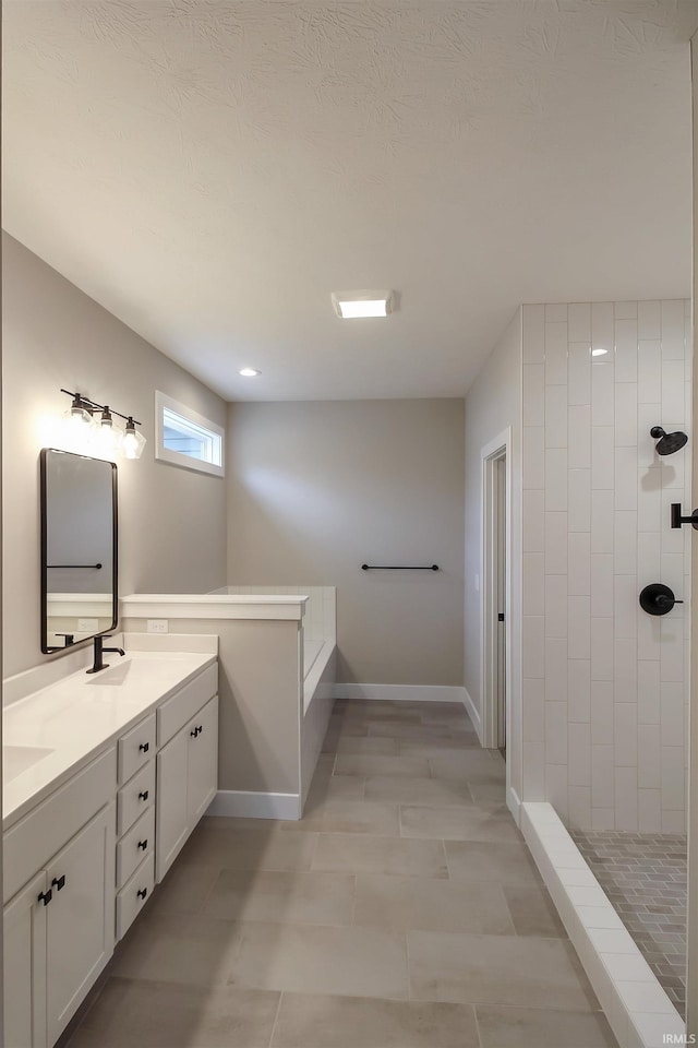 bathroom featuring double vanity, a stall shower, baseboards, tile patterned floors, and a sink