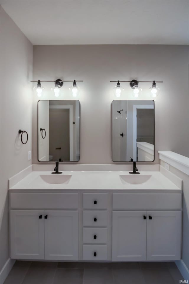 bathroom with tile patterned floors, a sink, and double vanity