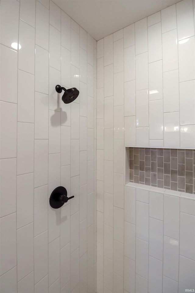 interior details featuring tiled shower and a package area