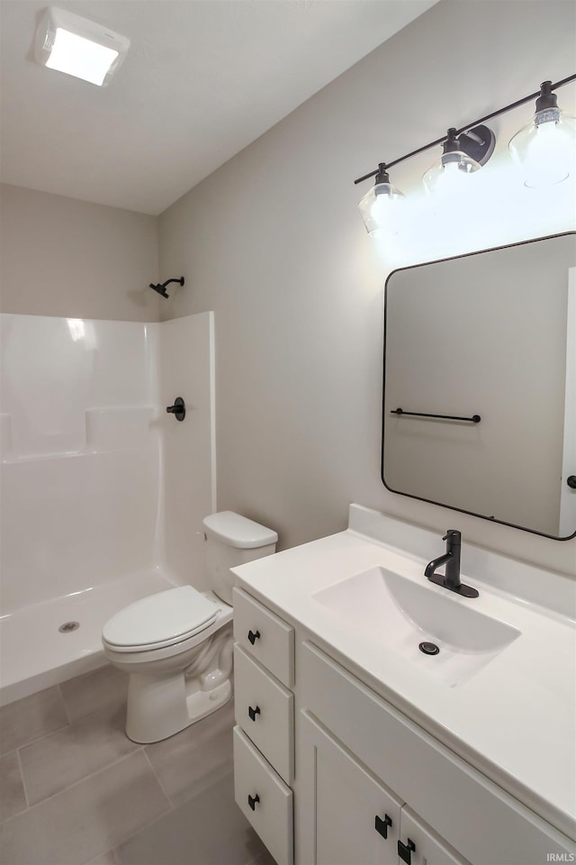 bathroom featuring toilet, tile patterned floors, walk in shower, and vanity