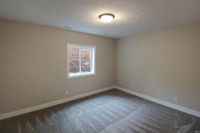 unfurnished room featuring a textured ceiling, carpet floors, visible vents, and baseboards