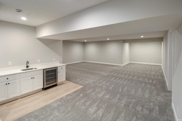 bar featuring baseboards, wine cooler, a sink, and recessed lighting