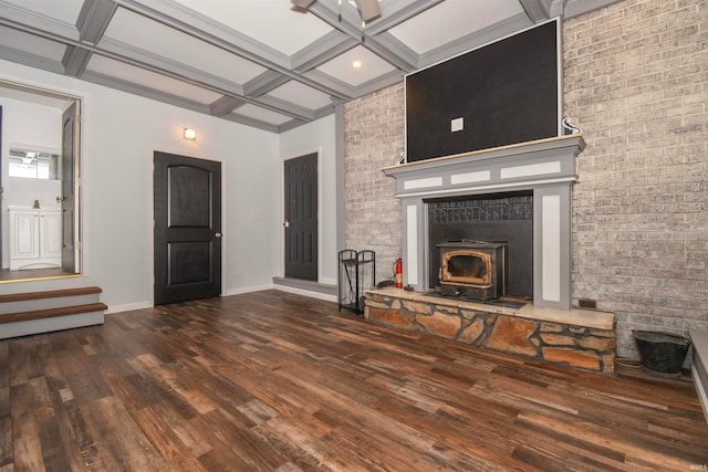 unfurnished living room with beamed ceiling, dark wood-type flooring, coffered ceiling, a fireplace, and brick wall