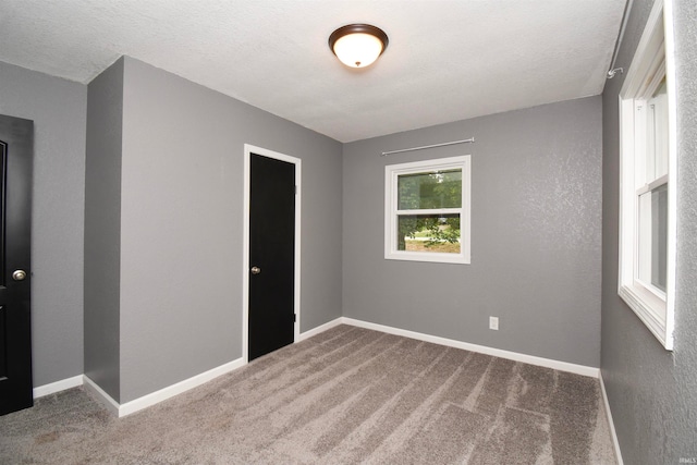 spare room featuring a textured ceiling and carpet floors