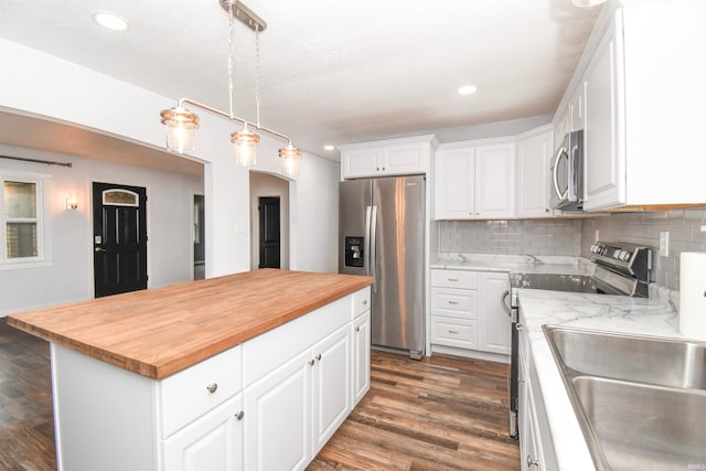 kitchen featuring a kitchen island, appliances with stainless steel finishes, dark wood-type flooring, and white cabinetry