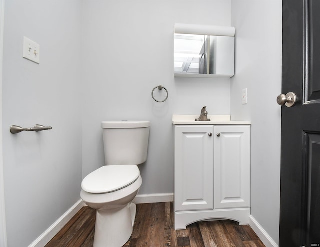 bathroom with wood-type flooring, vanity, and toilet